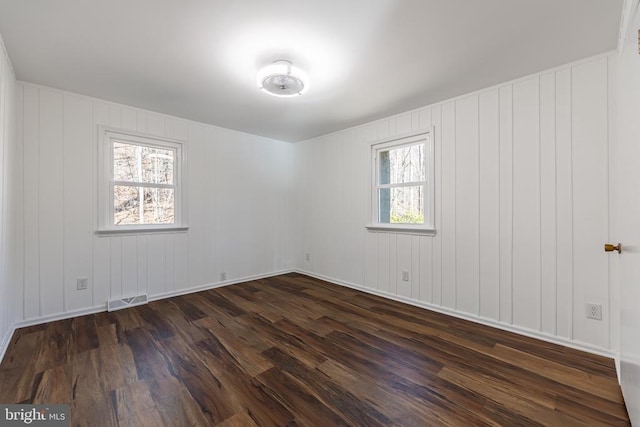 empty room with dark wood finished floors and visible vents