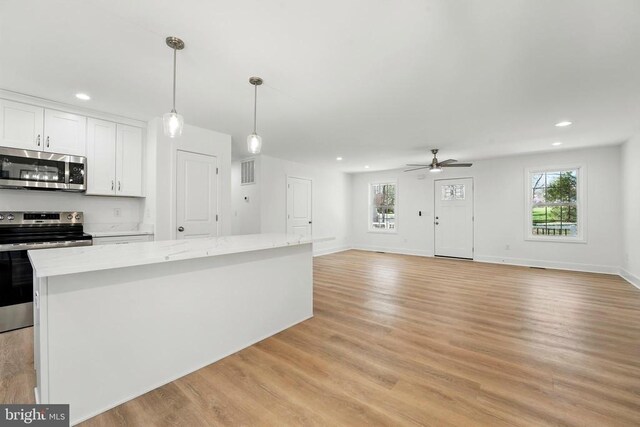 kitchen with a center island, appliances with stainless steel finishes, dark wood-style flooring, and french doors