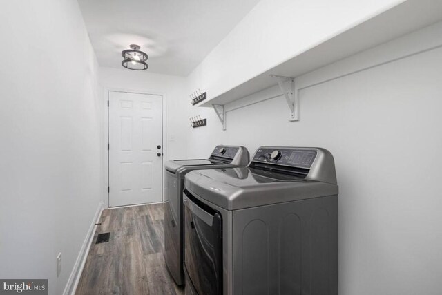 washroom with hardwood / wood-style floors and washer and clothes dryer