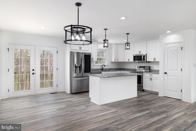 kitchen with french doors, white cabinetry, a center island, hanging light fixtures, and appliances with stainless steel finishes