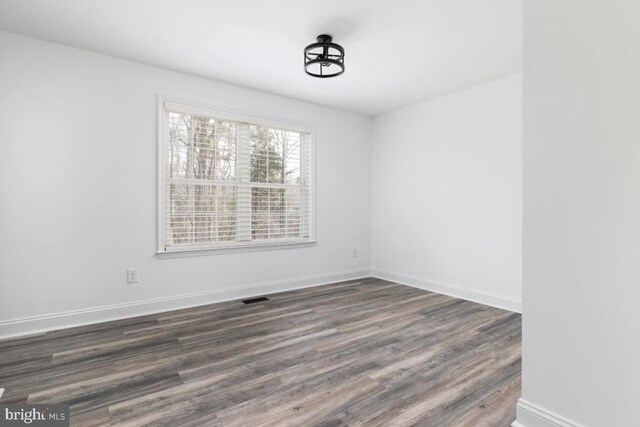 unfurnished room with dark hardwood / wood-style floors