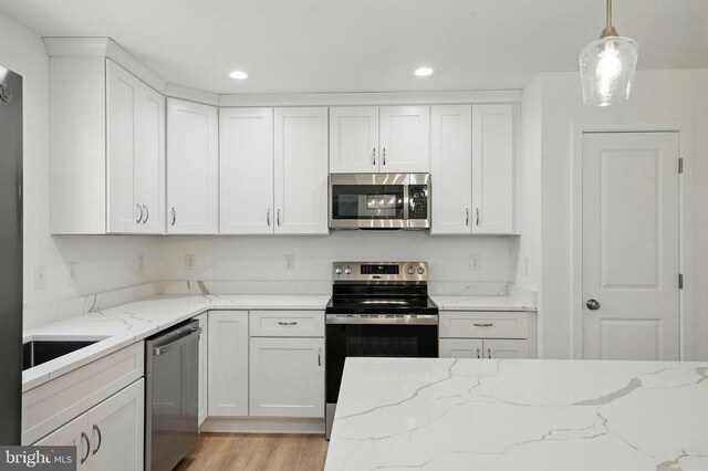 kitchen featuring stainless steel appliances, a center island, white cabinets, and visible vents