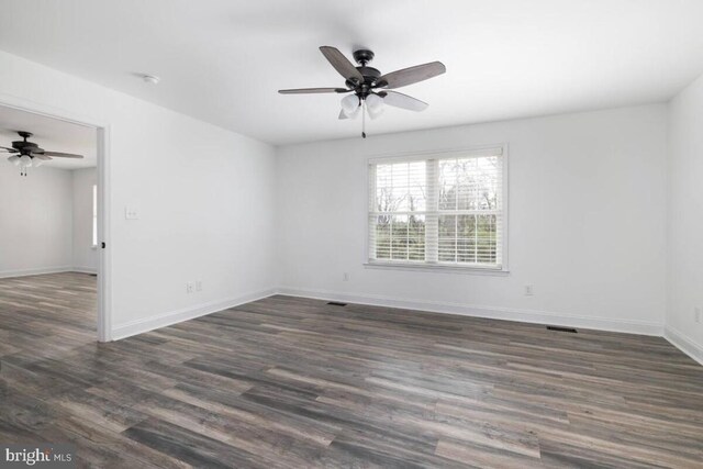 empty room featuring ceiling fan and dark hardwood / wood-style flooring