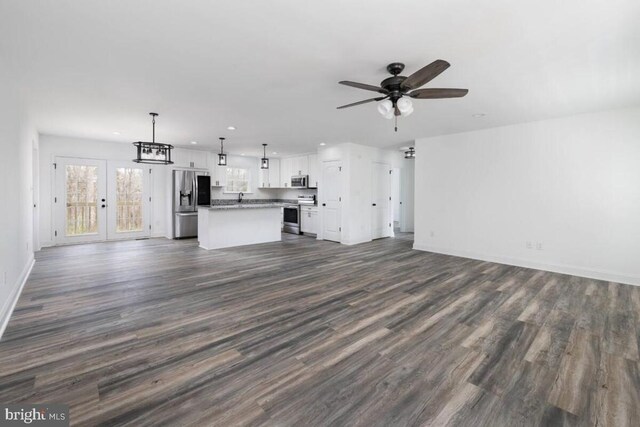 unfurnished living room featuring dark hardwood / wood-style flooring and ceiling fan