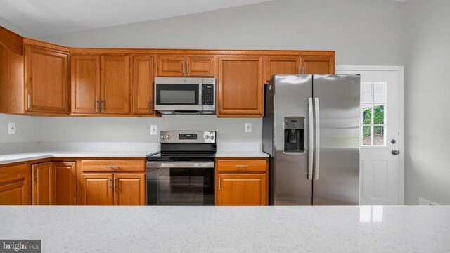 kitchen with vaulted ceiling and appliances with stainless steel finishes