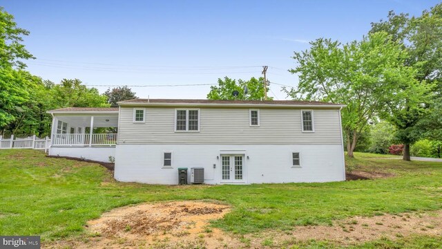 rear view of house featuring a yard, central AC, and french doors