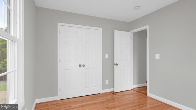 unfurnished bedroom featuring hardwood / wood-style flooring and a closet