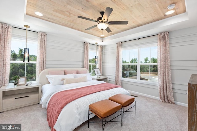 bedroom with light colored carpet, wooden ceiling, and a raised ceiling