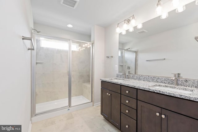 bathroom with an enclosed shower, vanity, and tile patterned floors