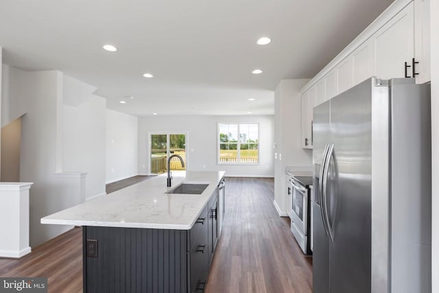 kitchen featuring sink, light stone counters, a center island with sink, stainless steel appliances, and white cabinets