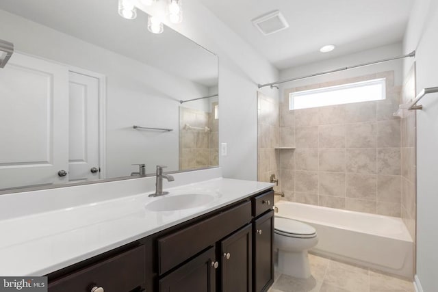 full bathroom featuring tile patterned floors, vanity, toilet, and tiled shower / bath combo