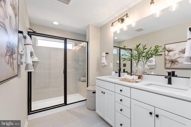 bathroom featuring vanity, tile patterned flooring, and a shower with shower door