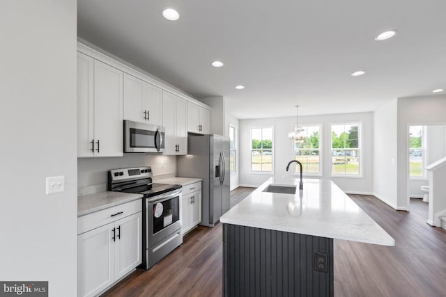 kitchen with pendant lighting, an island with sink, white cabinetry, sink, and stainless steel appliances