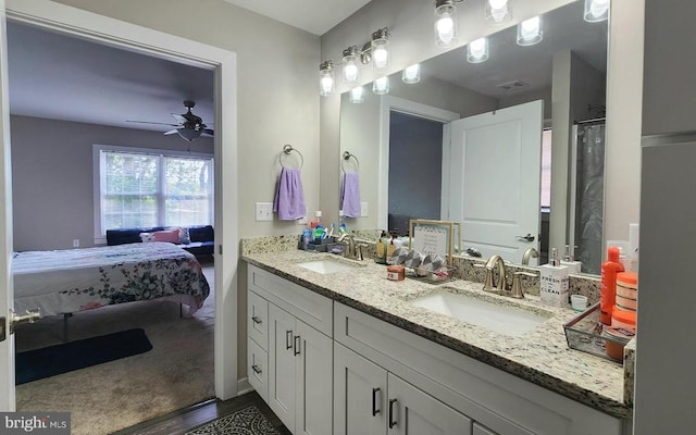 full bathroom featuring double vanity, a ceiling fan, a sink, and connected bathroom
