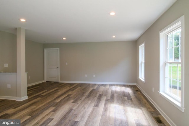 spare room with recessed lighting, baseboards, and wood finished floors