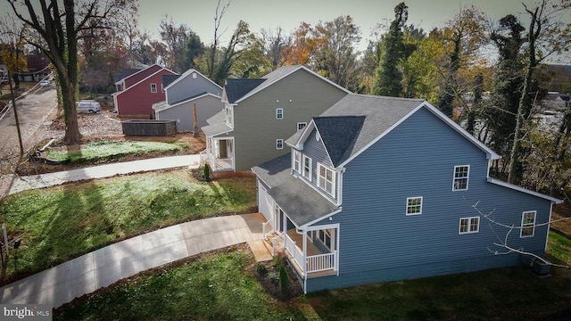 view of property exterior with a shingled roof and concrete driveway