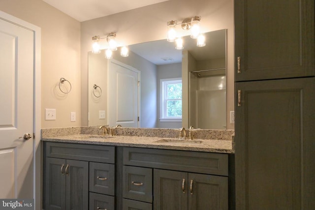 bathroom featuring a sink, walk in shower, and double vanity
