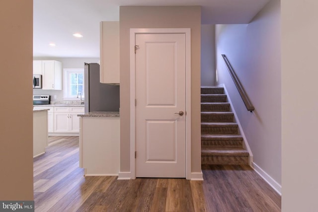 staircase featuring baseboards, recessed lighting, and wood finished floors