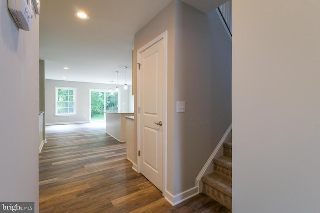 hall featuring recessed lighting, a wall mounted air conditioner, baseboards, and wood finished floors