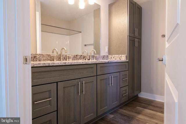 bathroom with baseboards, wood finished floors, and vanity