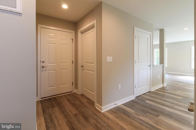 corridor featuring recessed lighting, baseboards, and dark wood finished floors