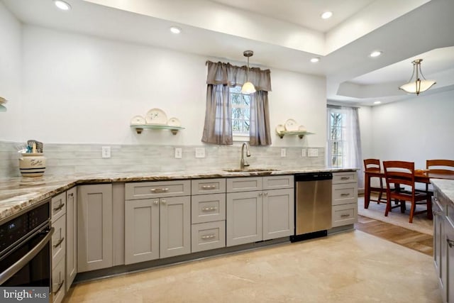 kitchen featuring gray cabinetry, sink, stainless steel appliances, and hanging light fixtures