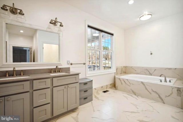 bathroom with vanity and tiled tub