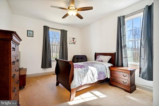 carpeted bedroom featuring multiple windows and ceiling fan