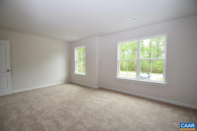 empty room with a wealth of natural light and light colored carpet