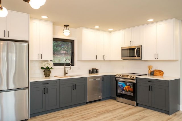 kitchen featuring stainless steel appliances, white cabinetry, and sink