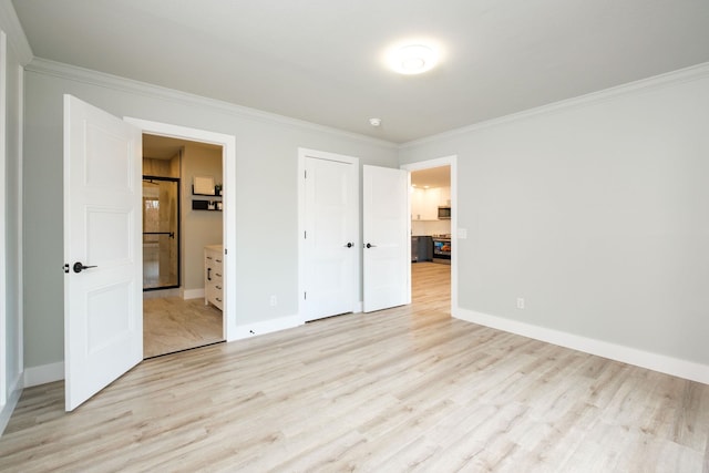 unfurnished bedroom featuring ornamental molding, ensuite bathroom, a closet, and light hardwood / wood-style flooring