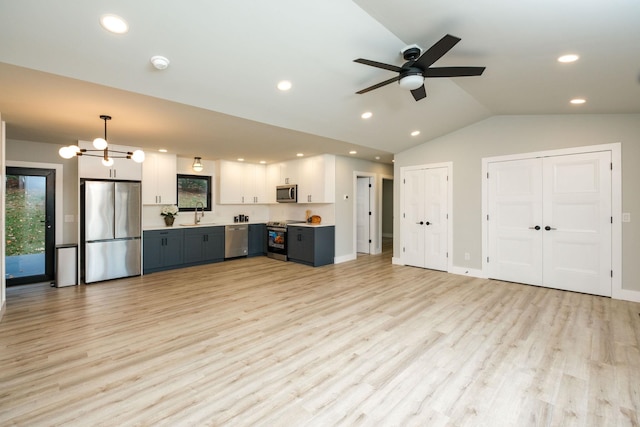 kitchen featuring white cabinetry, vaulted ceiling, light hardwood / wood-style flooring, appliances with stainless steel finishes, and pendant lighting