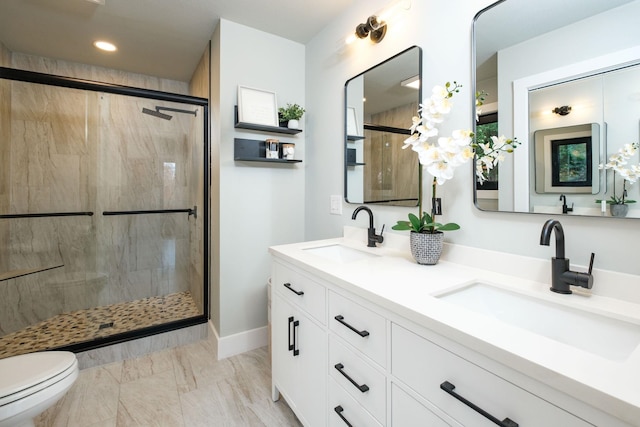 bathroom featuring vanity, a shower with shower door, and toilet