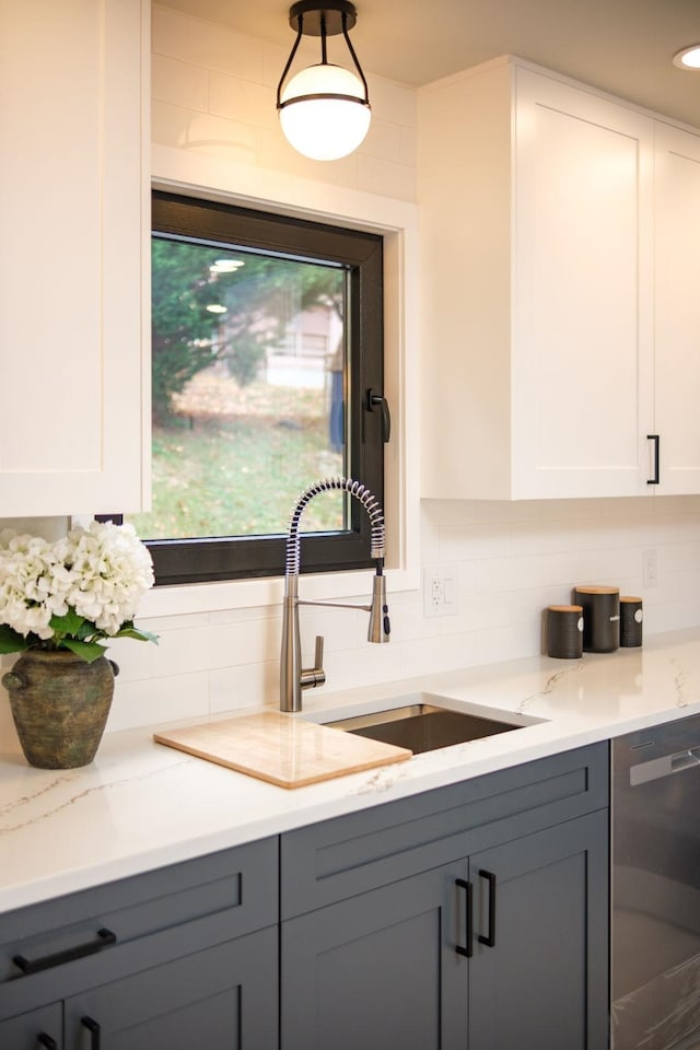 kitchen featuring white cabinetry, light stone counters, gray cabinetry, and dishwasher