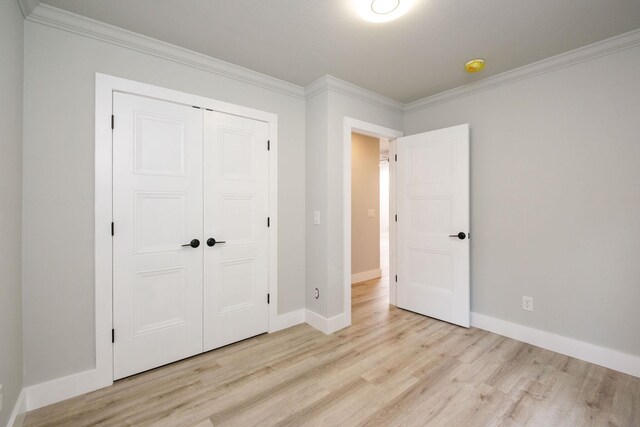 unfurnished bedroom featuring ornamental molding and light wood-type flooring