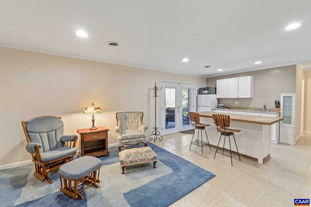 living room with crown molding, recessed lighting, visible vents, and baseboards