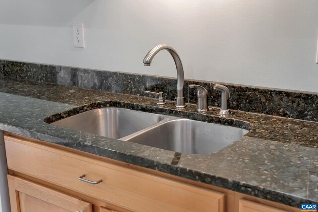 interior details featuring dark stone countertops and a sink