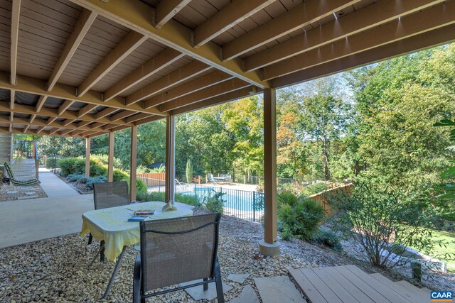 view of patio featuring a fenced in pool, outdoor dining area, and fence