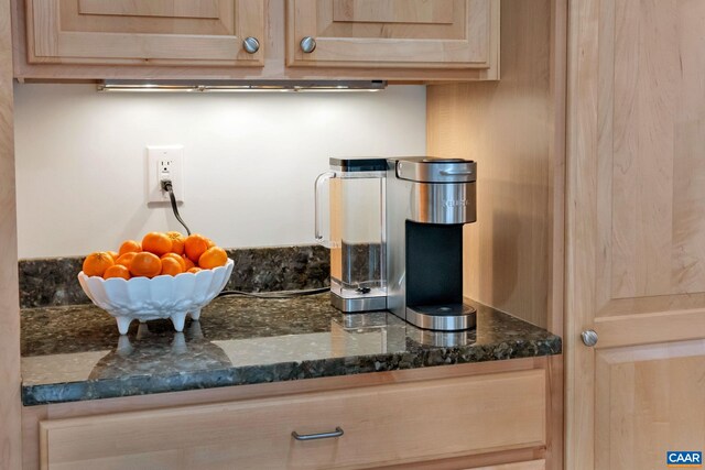 kitchen with light brown cabinets and dark stone counters