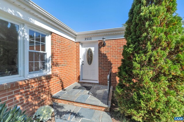 doorway to property featuring brick siding