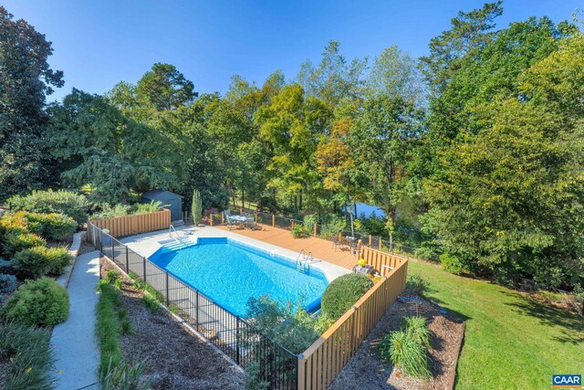 view of swimming pool with a fenced in pool, an outbuilding, a lawn, and fence