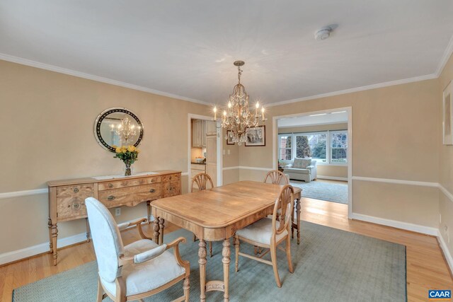 dining area featuring a notable chandelier, light wood-style flooring, and baseboards