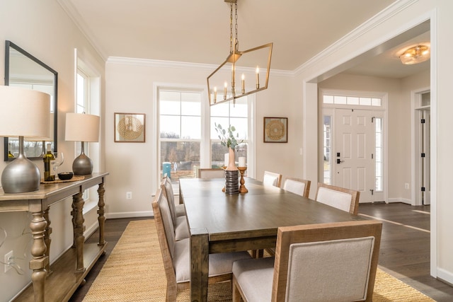 dining space with ornamental molding, dark hardwood / wood-style floors, and a notable chandelier