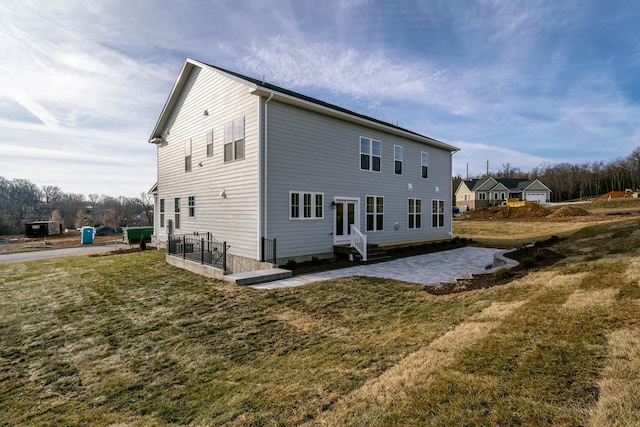 rear view of house with a lawn and a patio area