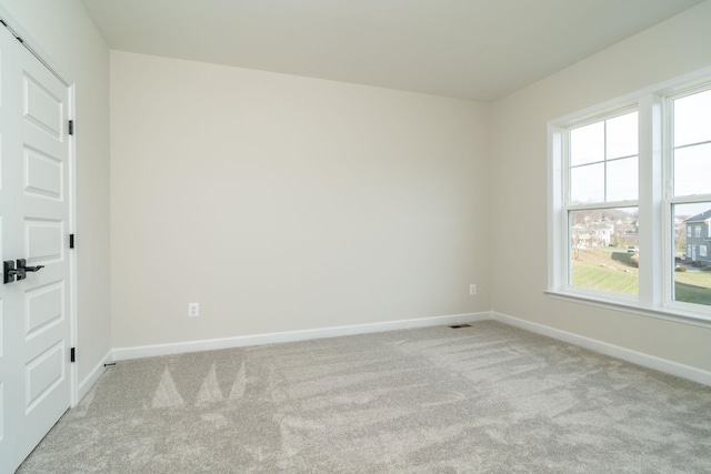 spare room featuring light carpet