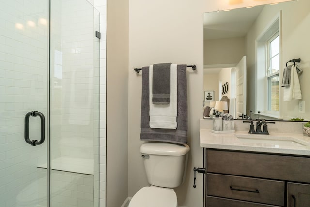 bathroom with vanity, toilet, and a shower with shower door