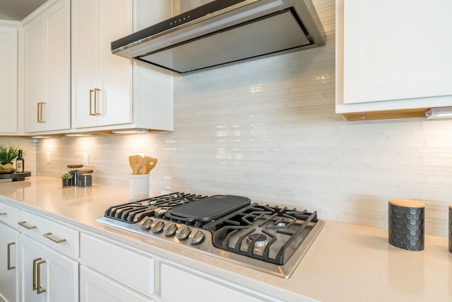 kitchen with white cabinetry, ventilation hood, stainless steel gas cooktop, and tasteful backsplash