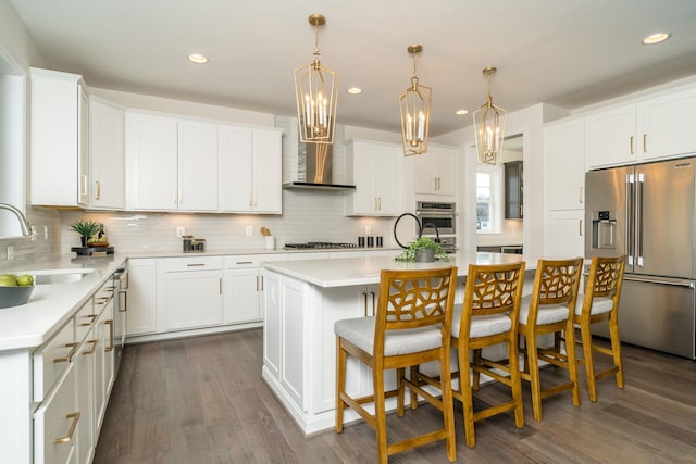 kitchen with a kitchen island, white cabinetry, sink, a breakfast bar area, and stainless steel appliances