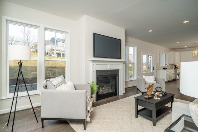 living room with an inviting chandelier and light wood-type flooring