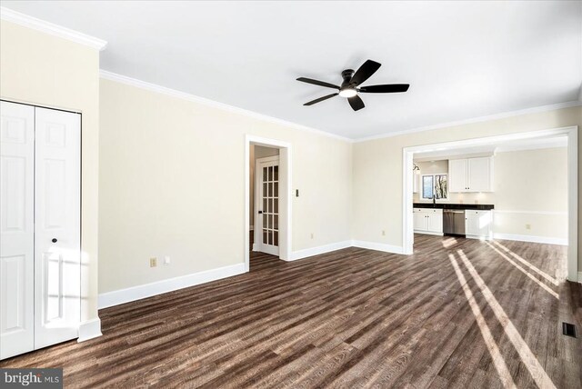 unfurnished living room with dark wood-type flooring, ceiling fan, ornamental molding, and sink